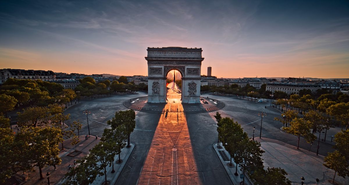 Triumfbuen i Paris med solnedgang bak monumentet